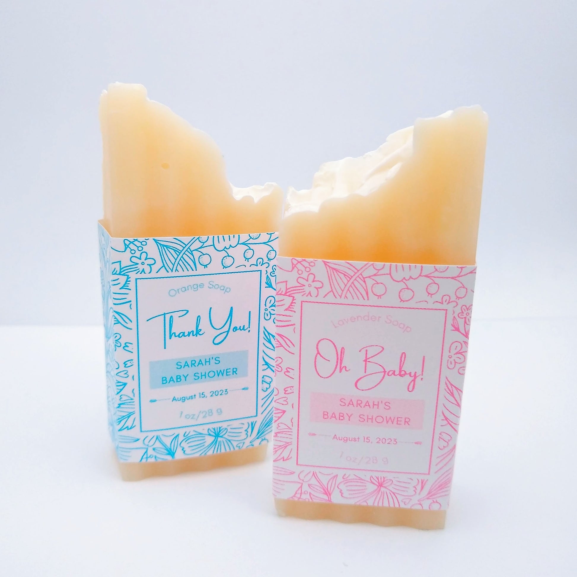 2 mini bar of cream-colored soap with one with a baby blue label printed with Thank You!, Sarah's Baby Shower, August 15, 2023. The second printed with Oh Baby!, Sarah's Baby Shower, August 15, 2023