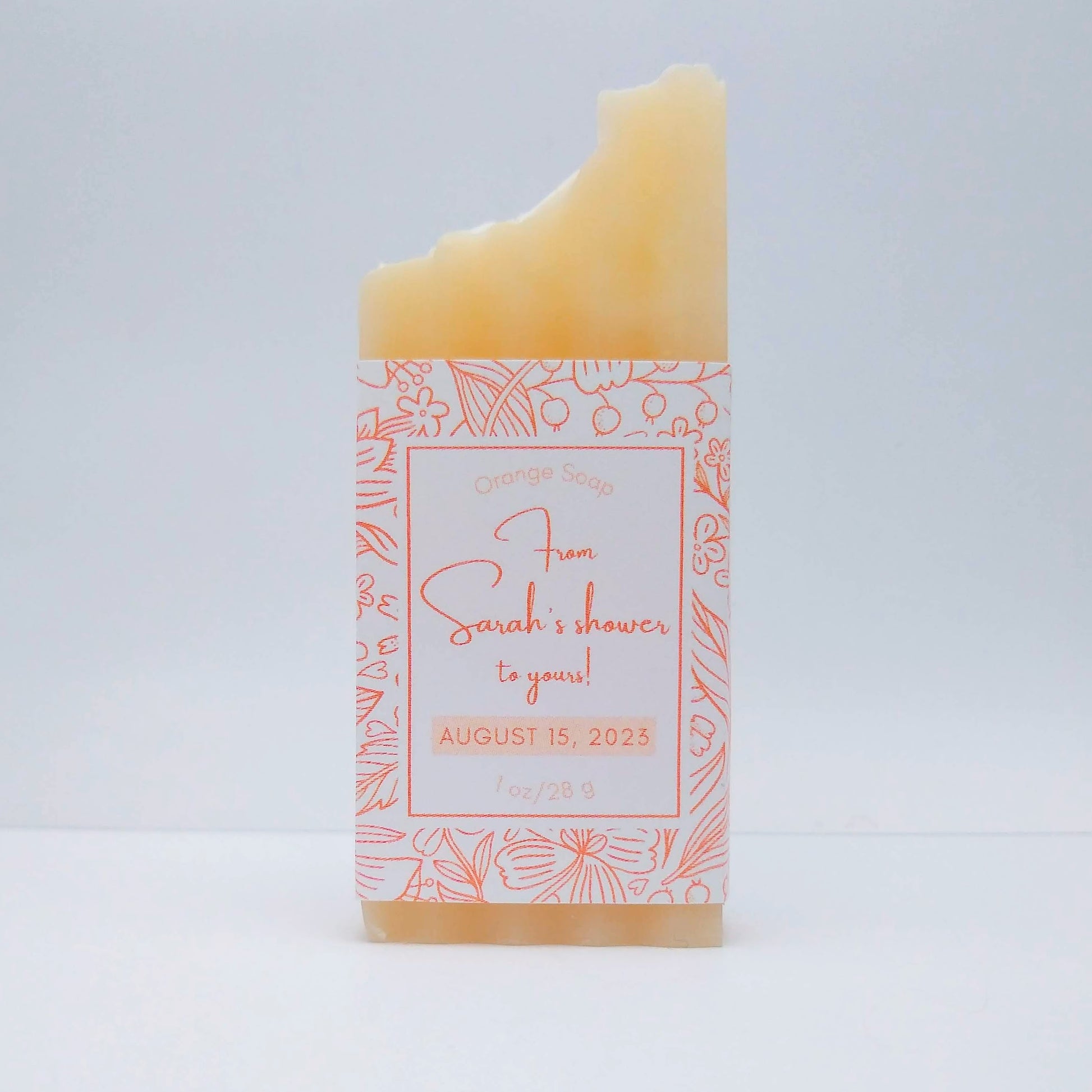 A mini bar of cream-colored soap with a light orange label printed with From Sarah's shower to yours!, August 15, 2023.