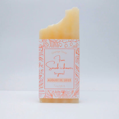 A mini bar of cream-colored soap with a light orange label printed with From Sarah's shower to yours!, August 15, 2023.