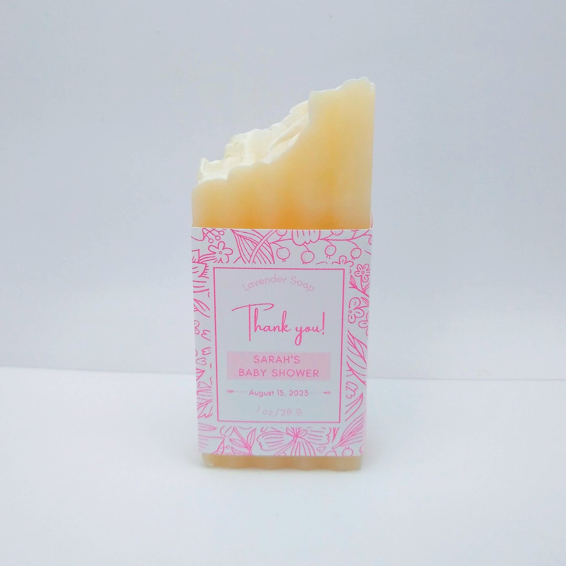 A mini bar of cream-colored soap with a pink label printed with Thank You!, Sarah's Baby Shower, August 15, 2023.